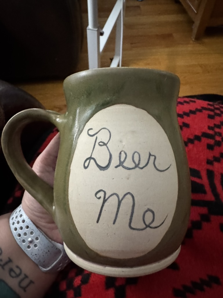 Photo of a ceramic mug that reads "Beer Me"