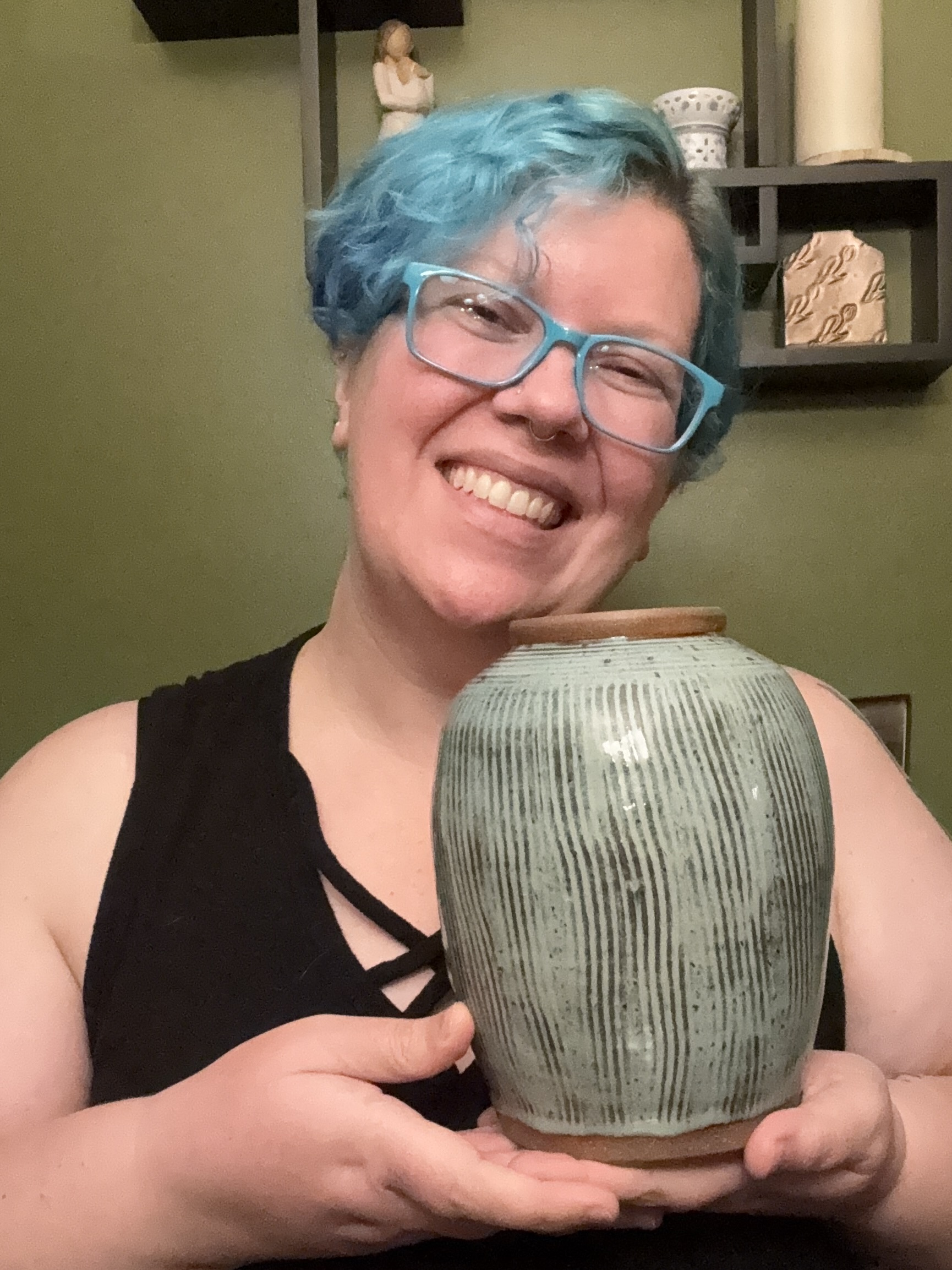 Photo of Karen from kmy pottery holding a large blue and brown vase